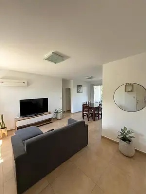a living room with a couch and a flat screen tv at Departamento Lago Los Molinos in Villa Ciudad de America