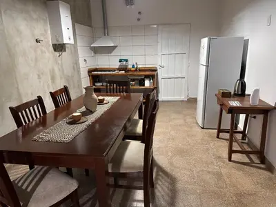 a kitchen with a table and chairs and a refrigerator at Lo de Capretta 2 in Almafuerte