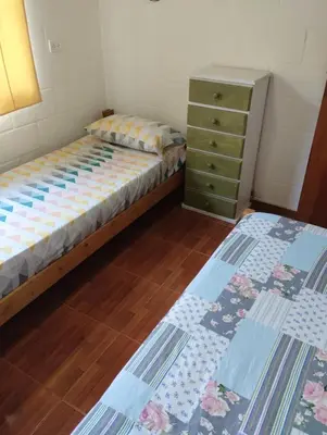 a bedroom with two twin beds and a dresser at Cabaña Villa del Dique, Calamuchita in Villa del Dique