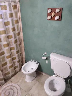 a bathroom with a white toilet and a sink at Cabaña Villa del Dique, Calamuchita in Villa del Dique