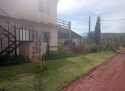 a house on the side of a dirt road at Cabaña Villa del Dique, Calamuchita in Villa del Dique