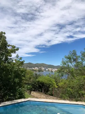 a swimming pool with a view of the water at casa vista al lago in Villa Carlos Paz