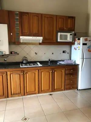 a kitchen with wooden cabinets and a white refrigerator at casa vista al lago in Villa Carlos Paz