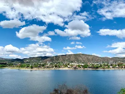 a view of a lake with a town and mountains at casa vista al lago in Villa Carlos Paz