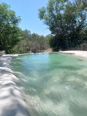 a large pool of water with trees in the background at Yuncasuma in Tanti