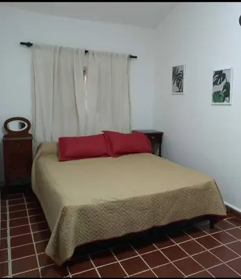 a bedroom with a bed with two red pillows at Yuncasuma in Tanti
