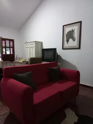 a red couch in a living room with a horse on the wall at Yuncasuma in Tanti