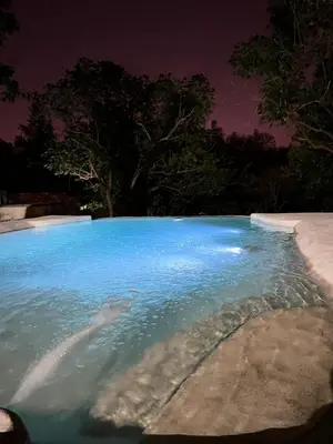 a swimming pool with blue water at night at Yuncasuma in Tanti