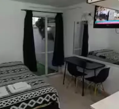 a bedroom with a bed and a desk with a computer at Rondeau Studios Apartaments in Cordoba