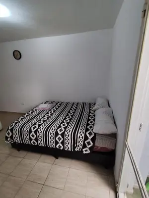 a bedroom with a bed with a black and white blanket at Rondeau Studios Apartaments in Cordoba