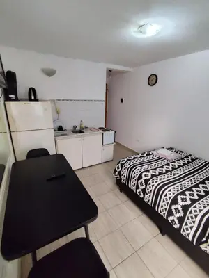 a bedroom with a bed and a table in it at Rondeau Studios Apartaments in Cordoba
