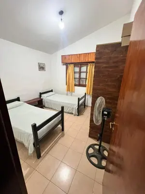a room with two beds and a chair in it at Mar y Sierras in La Paz