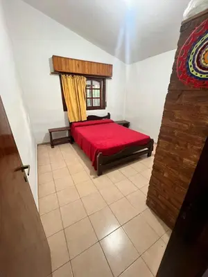 a bedroom with a red bed and a window at Mar y Sierras in La Paz
