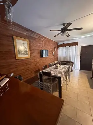 a dining room with a table and chairs and a ceiling fan at Santa Rita Dpto in Villa Carlos Paz