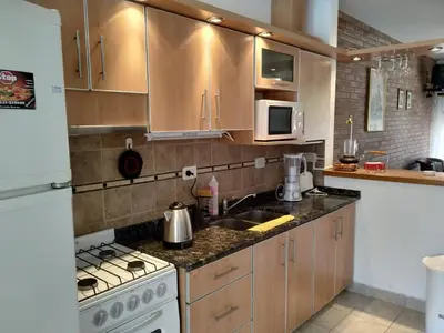 a kitchen with a sink and a stove top oven at Santa Rita Dpto in Villa Carlos Paz