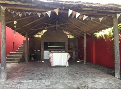 a pavilion with a table and a fireplace and stairs at Villa Gesell Diego Sarmiento in Villa Carlos Paz