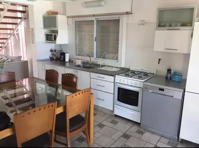 a kitchen with a table and a stove top oven at Villa Gesell Diego Sarmiento in Villa Carlos Paz
