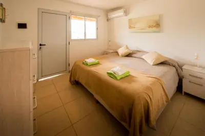 a bedroom with a bed with two green towels on it at Pipperland Hospedaje in Villa García