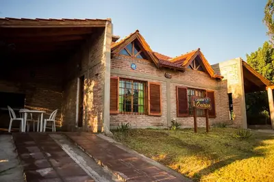 a wooden house with a sign in front of it at Cabañas Onírico - Duplex in Mina Clavero