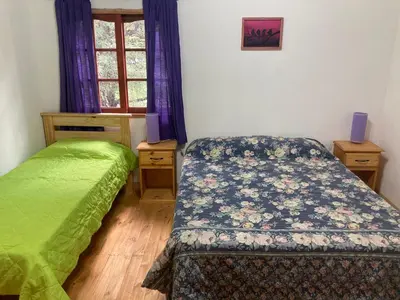 a bedroom with two twin beds and a window at Cabañas Onírico - Duplex in Mina Clavero
