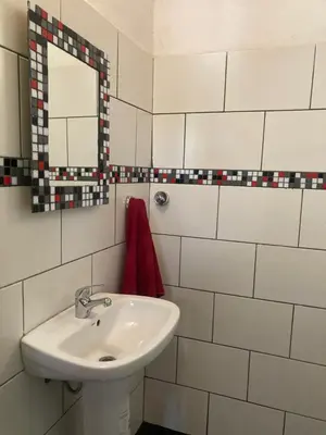 a white bathroom with a sink and a mirror at Cabañas Onírico - Duplex in Mina Clavero