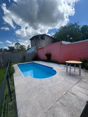 a small swimming pool with a table and a fence at Depto para 4 personas con pileta a 3 cuadras del rio in Villa Carlos Paz