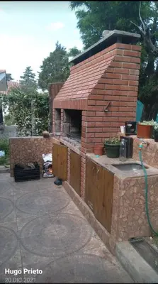 an outdoor brick pizza oven with a hose at Depto para 4 personas con pileta a 3 cuadras del rio in Villa Carlos Paz
