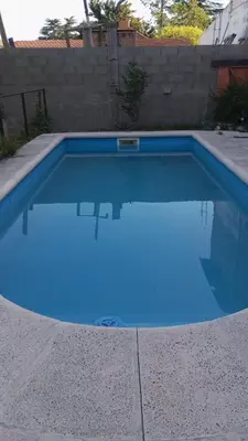 a swimming pool with blue water in a backyard at Depto para 4 personas con pileta a 3 cuadras del rio in Villa Carlos Paz