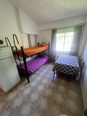 a room with two bunk beds and a table at Depto para 4 personas con pileta a 3 cuadras del rio in Villa Carlos Paz