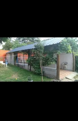 a building with a roof with a tree in the yard at Depto para 4 personas con pileta a 3 cuadras del rio in Villa Carlos Paz