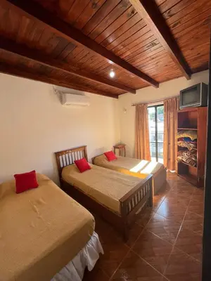 a bedroom with two beds and a tv and a fireplace at Crisol departamento in Alta Gracia