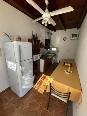a kitchen with a table and a white refrigerator at Crisol departamento in Alta Gracia