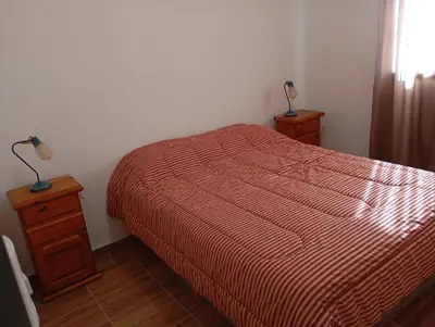 a bedroom with a bed and two lamps on a night stand at Los Espinillos in Villa Yacanto