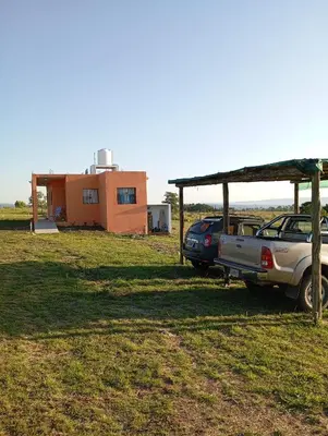 a house and two cars parked in a field at Los Espinillos in Villa Yacanto