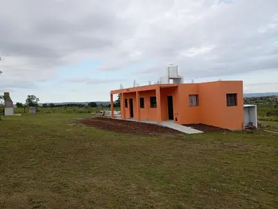 a small orange house in a field at Los Espinillos in Villa Yacanto