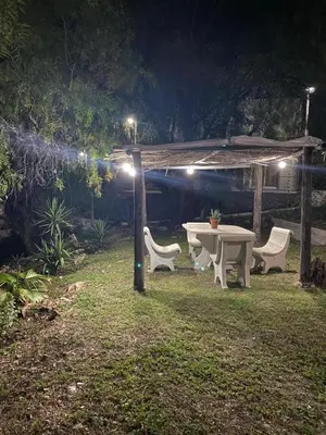 a picnic table and two chairs in a yard at night at Altos del Oeste in Villa Carlos Paz