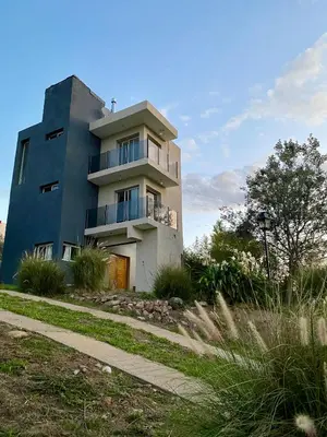 a tall building with a sidewalk in front of it at Altos del Oeste in Villa Carlos Paz