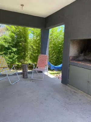 two chairs sitting on a patio with a fireplace at Altos del Oeste in Villa Carlos Paz