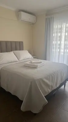 a bedroom with a bed with white sheets and a window at San Lorenzo - Nueva Córdoba in Cordoba