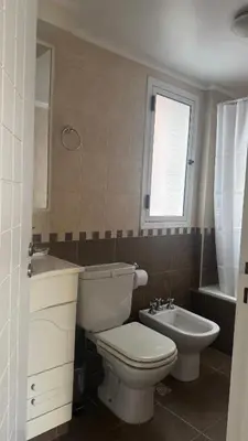a bathroom with a toilet and a sink and a window at San Lorenzo - Nueva Córdoba in Cordoba