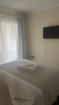 a bedroom with a bed with white sheets and a window at San Lorenzo - Nueva Córdoba in Cordoba