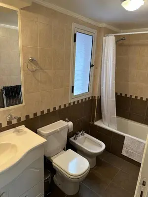 a bathroom with a toilet and a sink and a tub at San Lorenzo - Nueva Córdoba in Cordoba