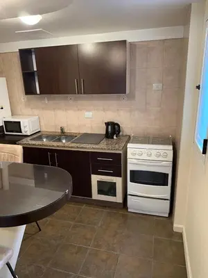 a kitchen with white appliances and a table at San Lorenzo - Nueva Córdoba in Cordoba