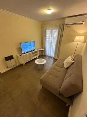 a living room with a couch and a flat screen tv at San Lorenzo - Nueva Córdoba in Cordoba
