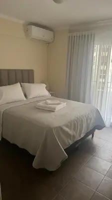 a bedroom with a bed with white sheets and a window at San Lorenzo - Nueva Córdoba in Cordoba