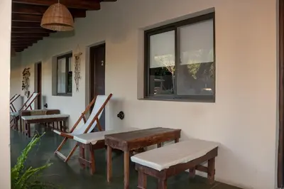 a row of wooden tables and chairs against a wall at Las Chuncas Posada Chill Villa de las Rosas in Villa de Las Rosas