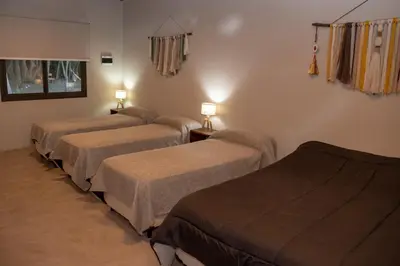 a room with three beds and two lamps on the wall at Las Chuncas Posada Chill Villa de las Rosas in Villa de Las Rosas