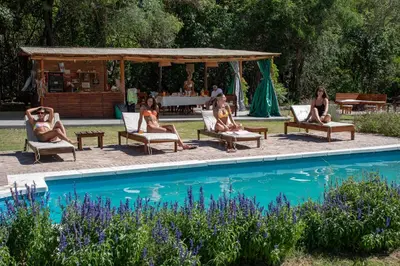 a group of people sitting in chairs by a pool at Las Chuncas Posada Chill Villa de las Rosas in Villa de Las Rosas