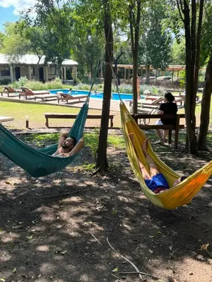 two children laying in hammocks in a park at Las Chuncas Posada Chill Villa de las Rosas in Villa de Las Rosas