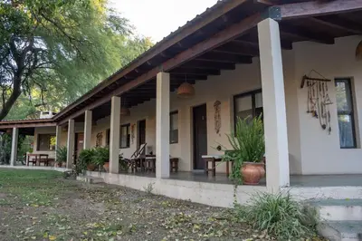 a building with a porch with tables and chairs at Las Chuncas Posada Chill Villa de las Rosas in Villa de Las Rosas